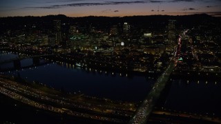 5.5K aerial stock footage of a view across the Burnside Bridge and Willamette River of Downtown Portland and the White Stag Sign, Oregon, at night Aerial Stock Footage | AX155_317E