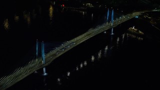 AX155_416E - 5.5K aerial stock footage orbiting Tilikum Crossing bridge as a commuter train crosses the span at night in South Portland, Oregon