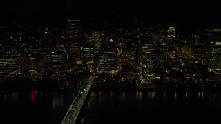 5.5K aerial stock footage passing waterfront skyscrapers by Hawthorne Bridge at night in Downtown Portland, Oregon Aerial Stock Footage | AX155_419