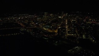 5.5K aerial stock footage of Downtown Portland skyscrapers at night seen while approaching Broadway Bridge, Oregon Aerial Stock Footage | AX155_428