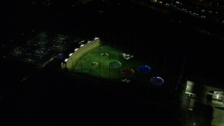 AX155_479E - 5.5K aerial stock footage orbiting Topgolf course in Hillsboro, Oregon at night