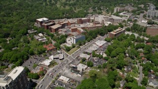 AX36_047E - 4.8K aerial stock footage following Peachtree Road past hospital, reveal office buildings and wooded areas, Buckhead