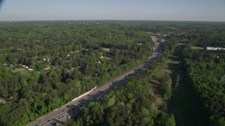 AX38_032 - 4.8K aerial stock footage orbiting an interstate with heavy traffic bordered by trees, West Atlanta, Georgia