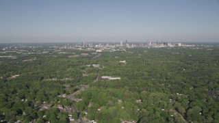 4.8K aerial stock footage flying over a junkyard and trees, tilt up revealing Midtown Atlanta, Georgia Aerial Stock Footage | AX38_033