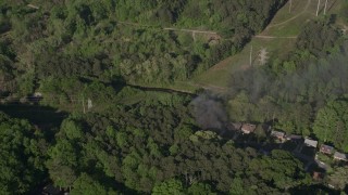 AX38_034E - 4.8K aerial stock footage of smoke rising from a house on fire in a wooded neighborhood, West Atlanta