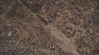 AX42_017 - 5K aerial stock footage fly over charred slopes to reveal rural homes destroyed by wildfires, Santa Monica Mountains, California