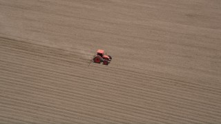 5K aerial stock footage track a tractor tilling a field, Camarillo, California Aerial Stock Footage | AX42_035