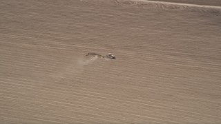 5K aerial stock footage track a tractor tilling the soil of a farm field, Camarillo, California Aerial Stock Footage | AX42_046