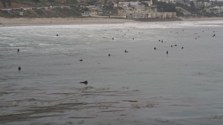 5K aerial stock footage approach surfers in the Pacific Ocean off the coast of Malibu, California Aerial Stock Footage | AX42_077E