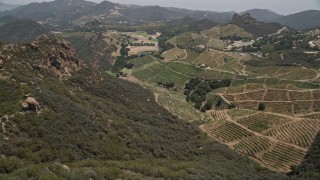 5K aerial stock footage approach and fly over rock formations to reveal hilly vineyards, Malibu, California Aerial Stock Footage | AX42_104E