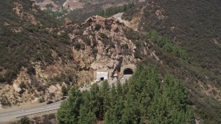 AX42_110 - 5K aerial stock footage of flying by a tunnel through a hill on Kanan Road, Malibu, California