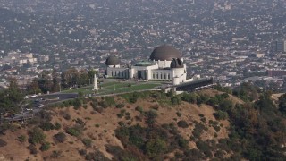 4K aerial stock footage of the Griffith Observatory seen while descending behind trees, Los Angeles Aerial Stock Footage | AX43_016E