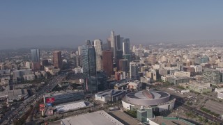 AX43_034E - 4K aerial stock footage tilting from heavy rush hour traffic on I-110 to reveal Staples Center, Ritz-Carlton and Downtown Los Angeles skyscrapers in California