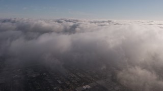 AX43_047E - 4K aerial stock footage flying over a dense marine layer over Los Angeles, California