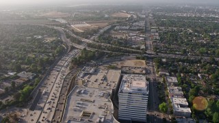 AX43_063E - 4K aerial stock footage flying over office buildings and the Sherman Oaks Galleria to approach heavy traffic on the I-405 and 101 interchange, Sherman Oaks, California