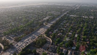 AX43_066 - 4K aerial stock footage tilting from a bird's eye view of heavy traffic on I-405 to reveal and pan across suburban neighborhoods, Van Nuys, California