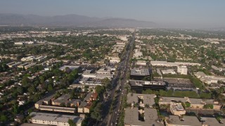 AX43_067 - 4K aerial stock footage flying by suburban neighborhoods, busy city streets, and office buildings, Van Nuys, California