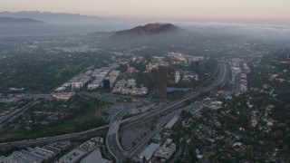 4K aerial stock footage of fog rolling near Universal City, Universal Studios, California, sunset Aerial Stock Footage | AX44_017E