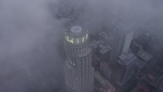 4K aerial stock footage of a bird's eye of US Bank Tower through marine layer, Downtown Los Angeles, twilight Aerial Stock Footage | AX44_038