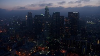 4K aerial stock footage approaching Downtown Los Angeles skyline below marine layer, twilight Aerial Stock Footage | AX44_068E