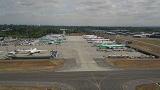 5K aerial stock footage of rows of commercial airplanes parked at Paine Field, Washington Aerial Stock Footage | AX45_150