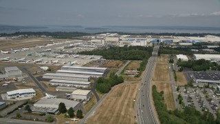 AX45_154 - 5K aerial stock footage approach the Boeing Factory and pan to parked airliners, Paine Field, Washington