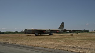 AX45_158 - 5K aerial stock footage of a military jet parked in a field at Paine Field, Washington