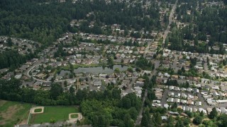 AX46_014 - 5K aerial stock footage flying by suburban homes around a pond, Brier, Washington