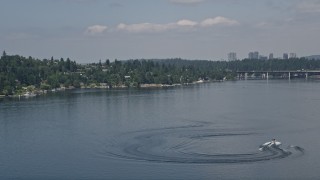 AX46_046 - 5K aerial stock footage of tracking a speedboat pulling a raft on Lake Washington, Washington