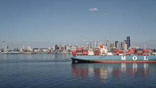 5K aerial stock footage flyby a cargo ship and tugboat sailing Elliott Bay to focus on the Downtown Seattle skyline, Washington Aerial Stock Footage | AX47_030E