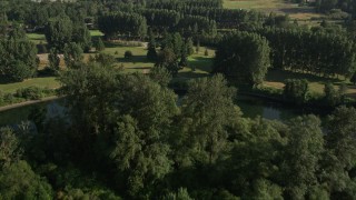 AX48_034E - 5K aerial stock footage fly over green field, trees, and a bend in the river to reveal a golf course, Carnation, Washington