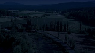 4K day for night color corrected aerial stock footage of tall trees and the Snoqualmie River near crop fields in Carnation, Washington Aerial Stock Footage | AX48_039_DFN