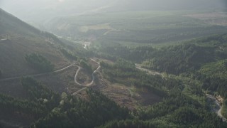 5K aerial stock footage fly over forest and logging area to approach a road at the base of a mountain in King County, Washington Aerial Stock Footage | AX48_066