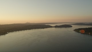 5K aerial stock footage of the distant Downtown Seattle skyline seen while flying over Lake Washington at sunset Aerial Stock Footage | AX50_004E