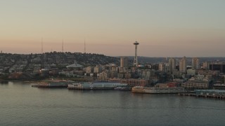 5K aerial stock footage reverse view of the Seattle Space Needle and Central Waterfront piers at sunset, Downtown Seattle, Washington Aerial Stock Footage | AX50_011