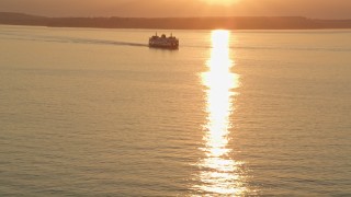 5K aerial stock footage of setting sun over a ferry sailing Elliott Bay, Washington, sunset Aerial Stock Footage | AX50_013E