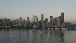 5K aerial stock footage of the Central Waterfront and the Downtown Seattle skyline while flying by ferries sailing Elliott Bay, Washington, sunset Aerial Stock Footage | AX50_035