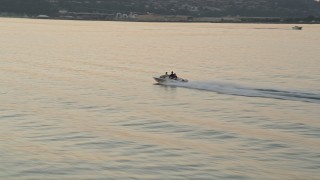 5K aerial stock footage of tracking a speedboat cruising across Elliott Bay, Seattle, Washington, sunset Aerial Stock Footage | AX50_036