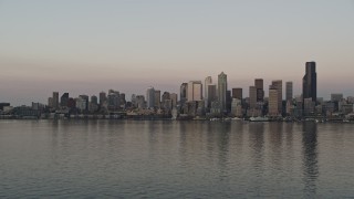 5K aerial stock footage of view of the Downtown Seattle skyline from Elliott Bay, revealing a ferry sailing the bay, Washington, sunset Aerial Stock Footage | AX50_045