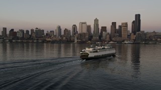 5K aerial stock footage track a ferry sailing Elliott Bay toward the Seattle Waterfront and Downtown Seattle skyline in Washington, sunset Aerial Stock Footage | AX50_047