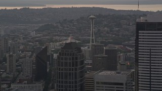 5K aerial stock footage of Seattle Space Needle seen while passing tall skyscrapers in Downtown Seattle, Washington, sunset Aerial Stock Footage | AX50_052E