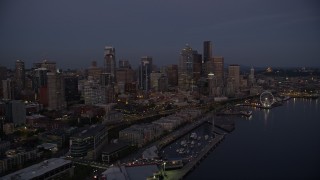 AX50_091E - 5K aerial stock footage of passing the Downtown Seattle skyline, Central Waterfront piers and Seattle Great Wheel, Washington, twilight