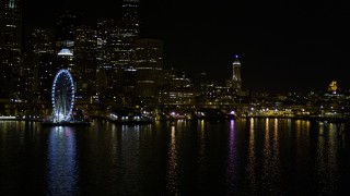 AX51_046E - 5K aerial stock footage approach Central Waterfront piers near the Seattle Great Wheel at night, Downtown Seattle, Washington