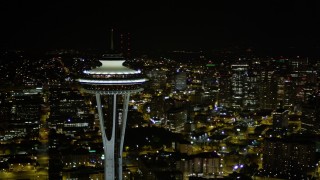 AX51_074E - 5K aerial stock footage orbit top of the Space Needle to reveal and focus on Downtown Seattle skyscrapers, Washington, night