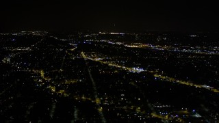 AX51_096E - 5K aerial stock footage tilt from a strip mall to reveal neighborhoods at night in Rainier Valley, Seattle, Washington