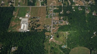 AX52_007 - 5K aerial stock footage of bird's eye view of rural homes and wide, green fields in Auburn, Washington