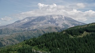 AX52_040E - 5K aerial stock footage approach Mount St. Helens, capped by clouds, Washington