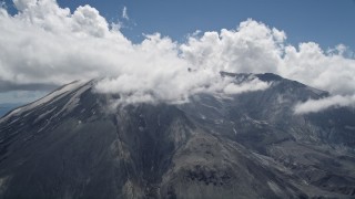 AX52_050E - 5K aerial stock footage orbit Mount St. Helens with cloud coverage and snow patches, Washington