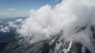 AX52_055 - 5K aerial stock footage tilt up the snowy slope of Mount St. Helens with summit clouds, Washington