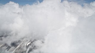 AX52_058 - 5K aerial stock footage orbit Mount St. Helens with snowy slopes peeking through thick cloud coverage, Washington